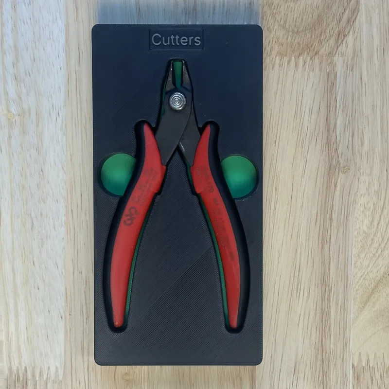 The wire cutters in their shadowbox, with green finger holes